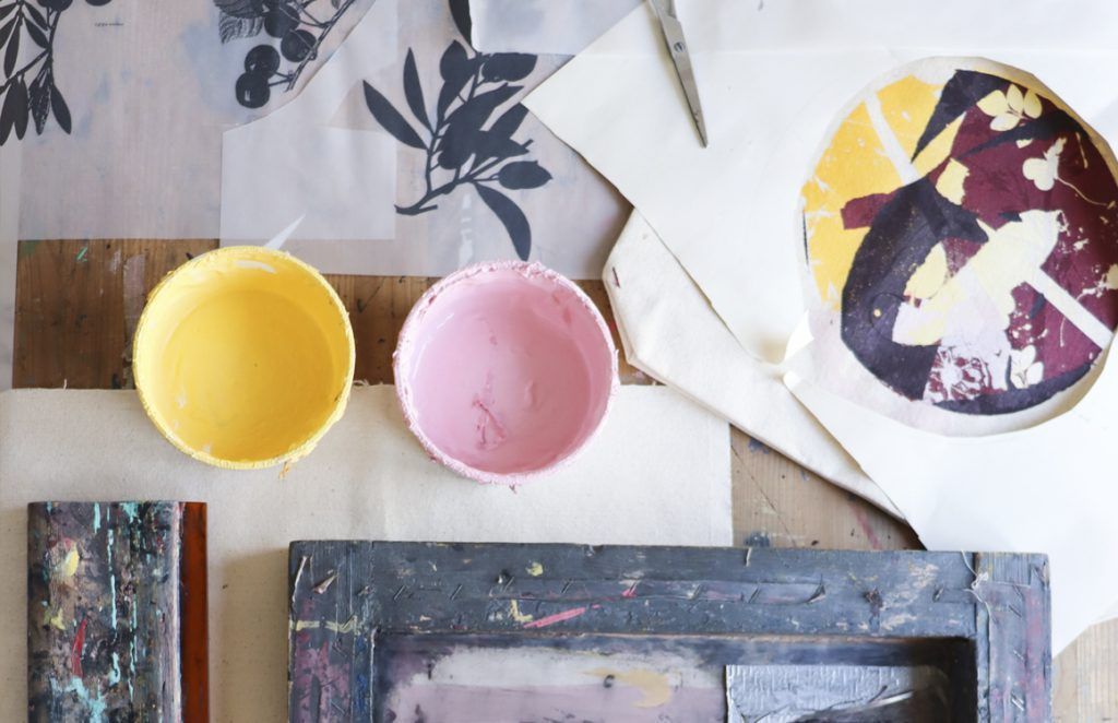 Detalle de una mesa con materiales, pantalla y colores para la estampación de serigrafía