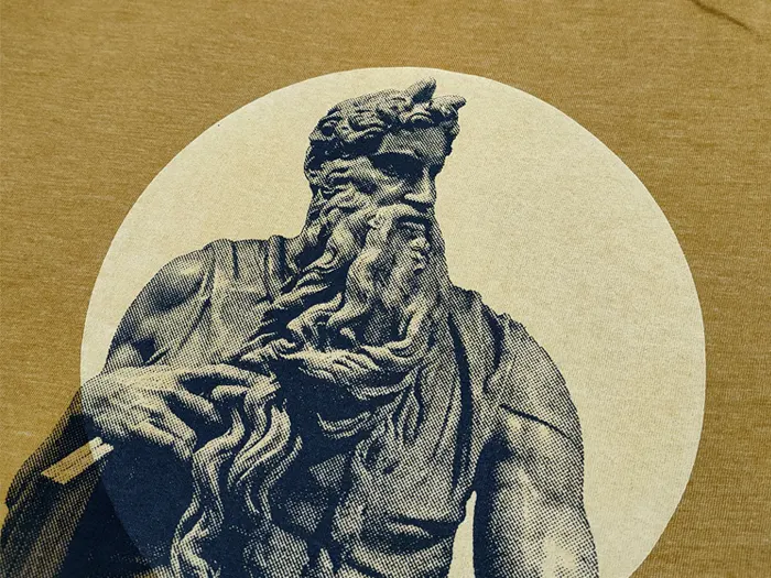Detalle de un dios Griego estampado sobre tela en blanco y negro con una trama y con un circulo beige al fondo