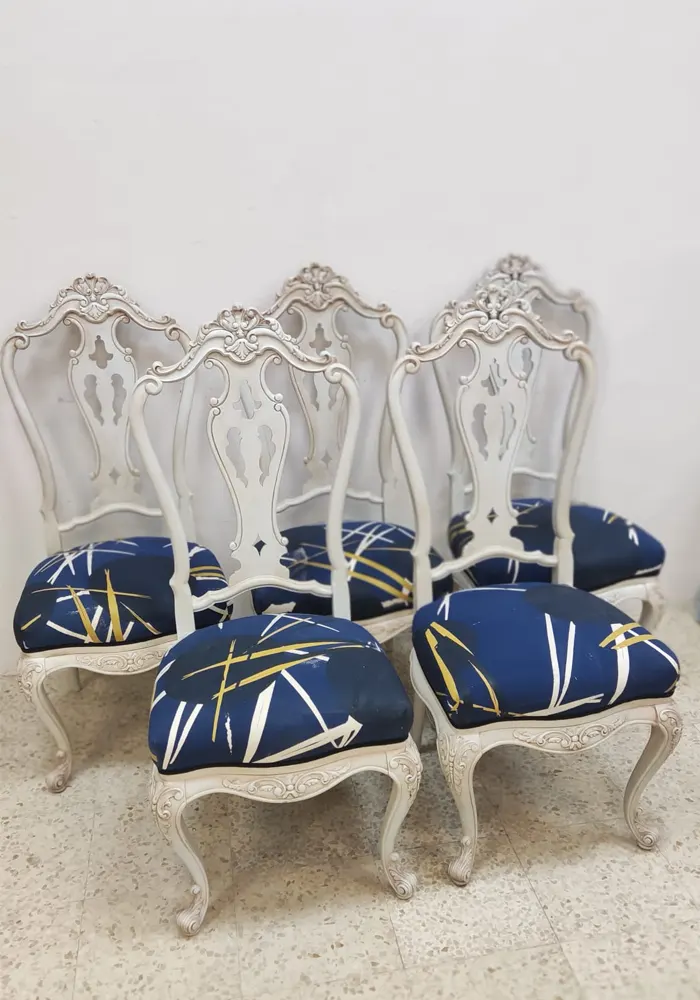 Imagen de sillas cásicas con un estampado moderno en la tela de estas de color azul y líneas blancas y doradas