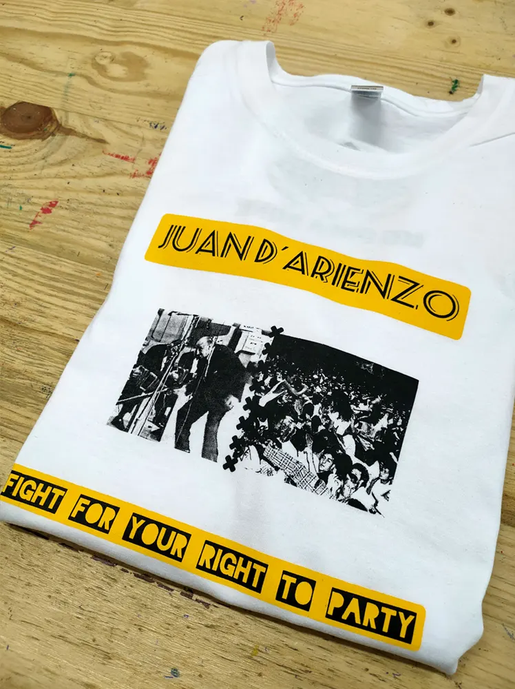 Camiseta blanca con un diesño en amarillo y foto en blanco y negro de Milonga Punk