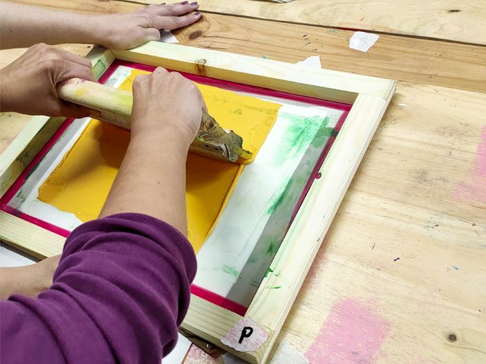 manos estampando con pantalla de serigrafia